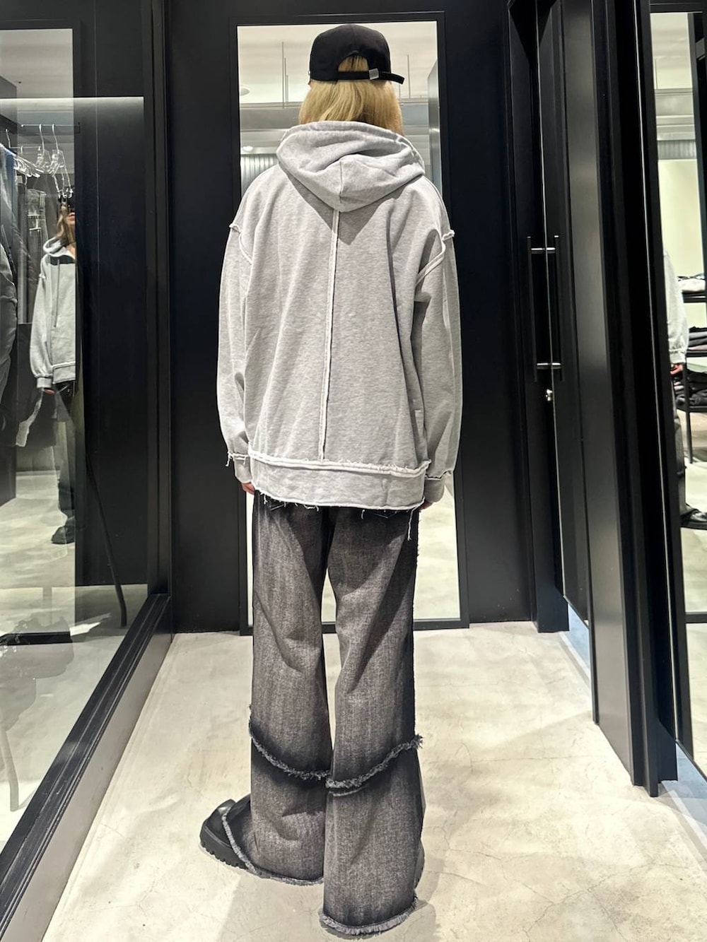 ブラック系のデニムパンツ、グレー系のパーカー、ブラック系のキャップを着用したメンズの秋コーディネートの3枚目の写真