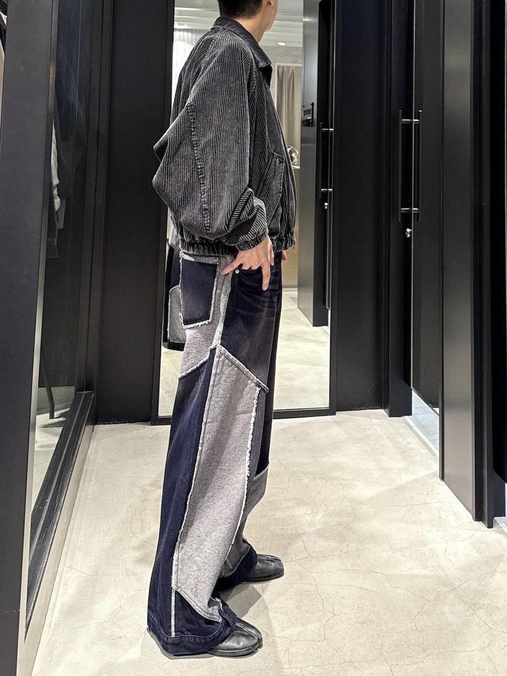 ブラック系のブルゾン、ブルー系のデニムパンツ、ブラック系のスウェットを着用したメンズの秋コーディネートの2枚目の写真