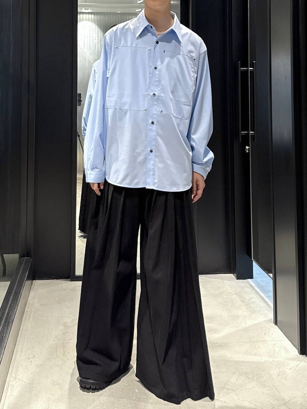 ホワイト系のTシャツ/カットソー、ブラック系のデニムパンツ、ブラック系のブーツを着用したメンズの秋コーディネートの4枚目の写真