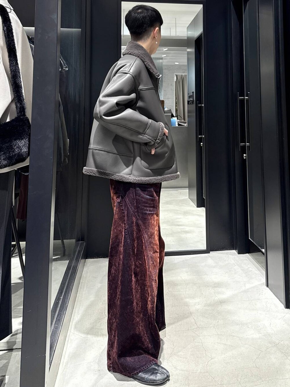 グレー系のブルゾン、レッド系のデニムパンツを着用したメンズの秋コーディネートの2枚目の写真