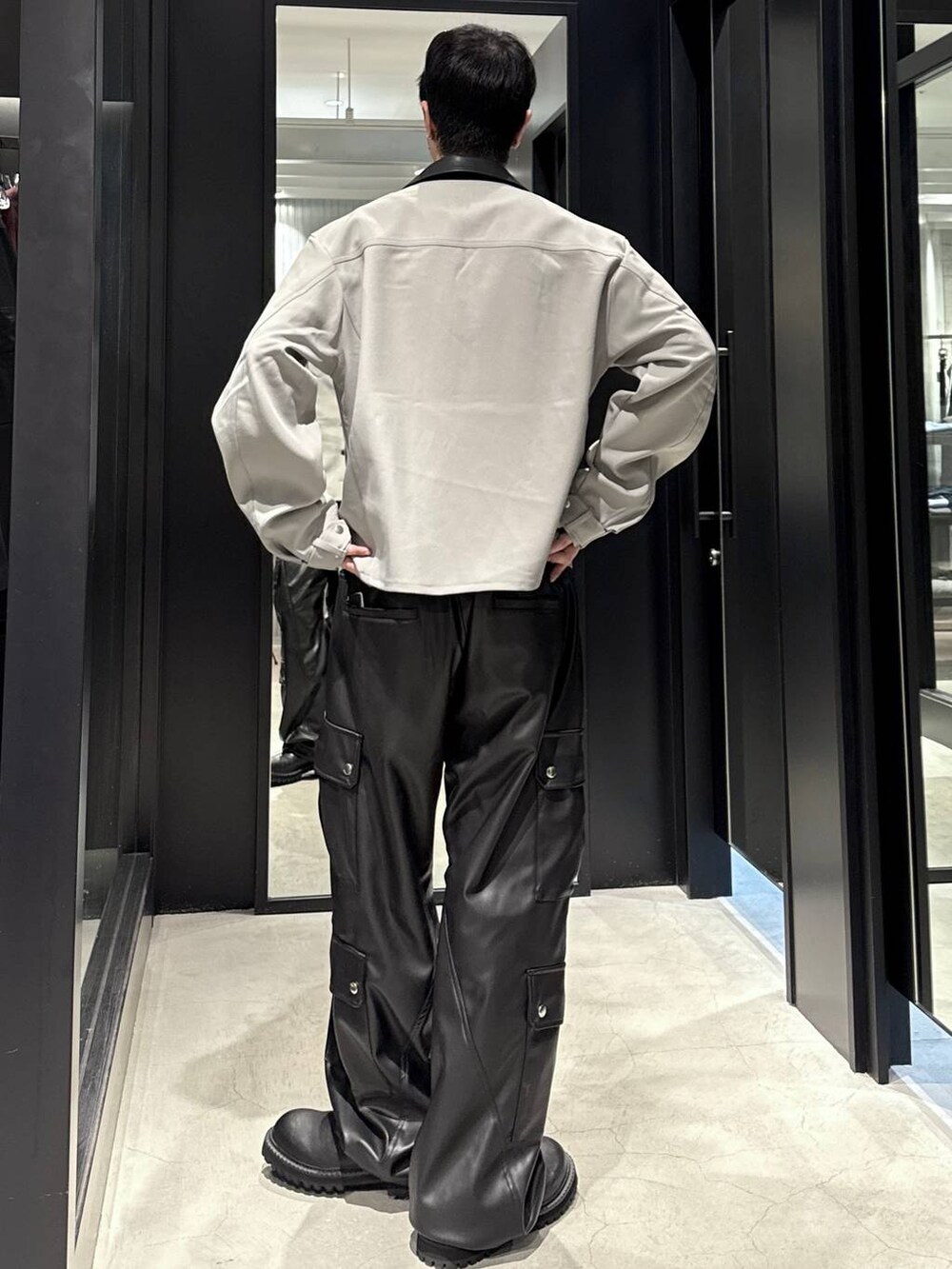 ブラック系のタンクトップ、ブラック系のカーゴパンツ、ブラック系のブーツを着用したメンズの秋コーディネートの3枚目の写真
