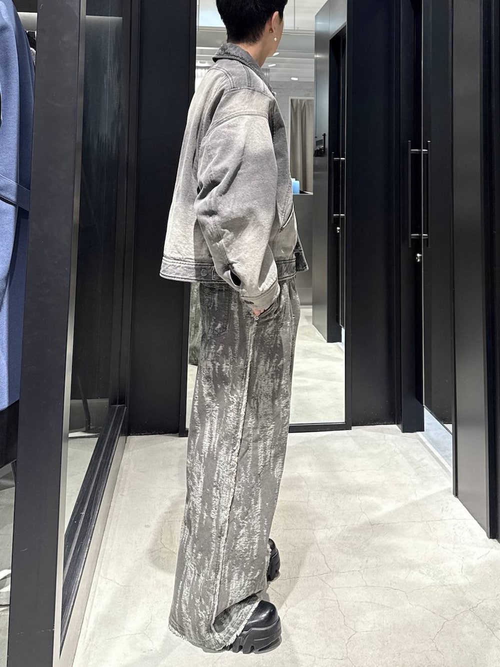 グレー系のブルゾン、ホワイト系のネックレスを着用したメンズの冬コーディネートの2枚目の写真