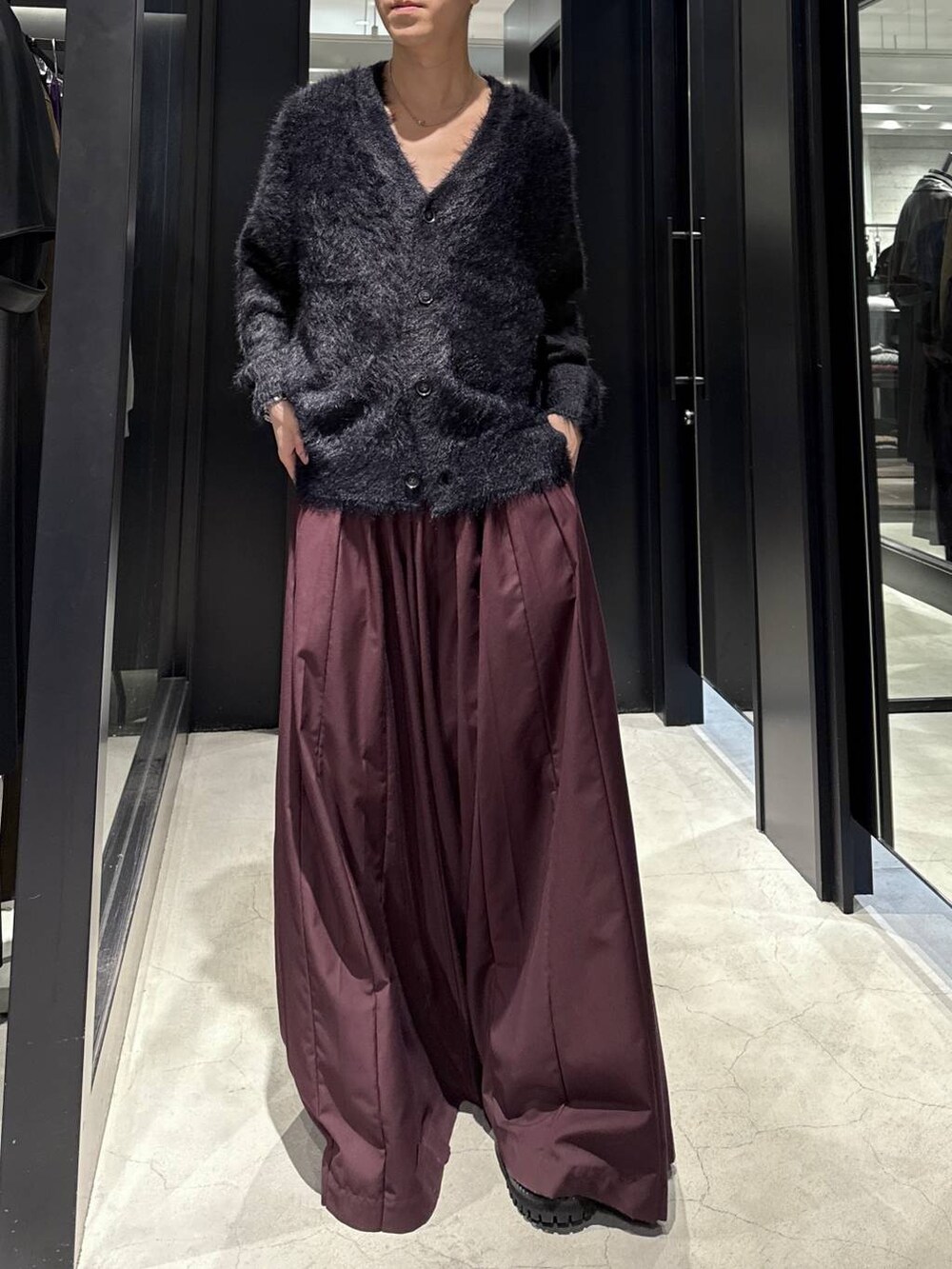 ブラック系のカーディガン/ボレロ、ブラック系のブーツ、レッド系のその他パンツを着用したメンズの秋コーディネートの4枚目の写真