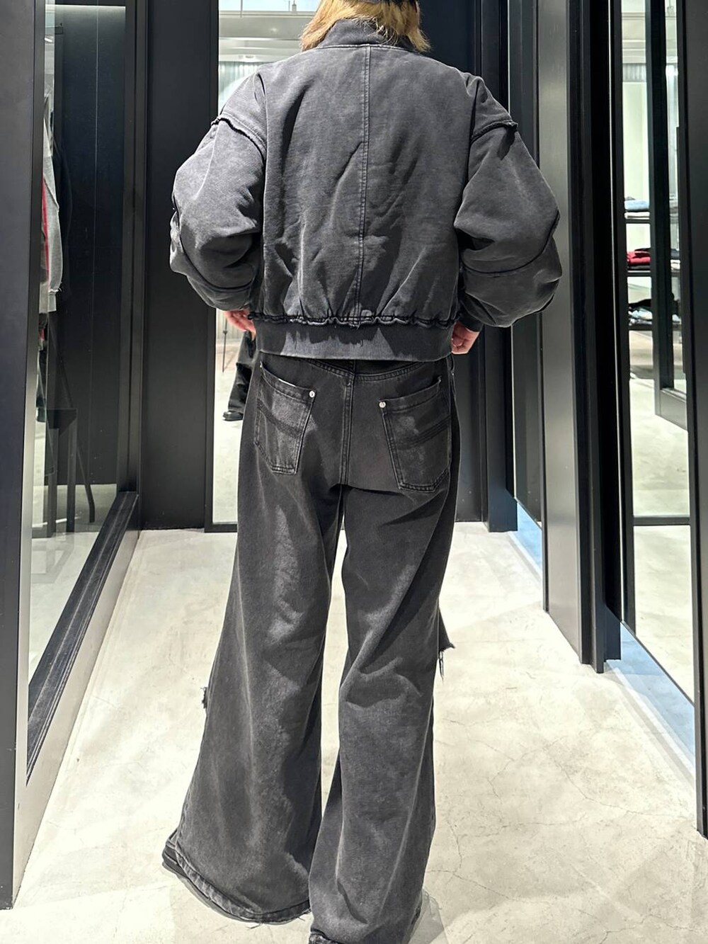 ブラック系のデニムパンツ、ブラック系のブルゾン、グレー系のニットキャップ/ビーニーを着用したメンズの秋コーディネートの5枚目の写真