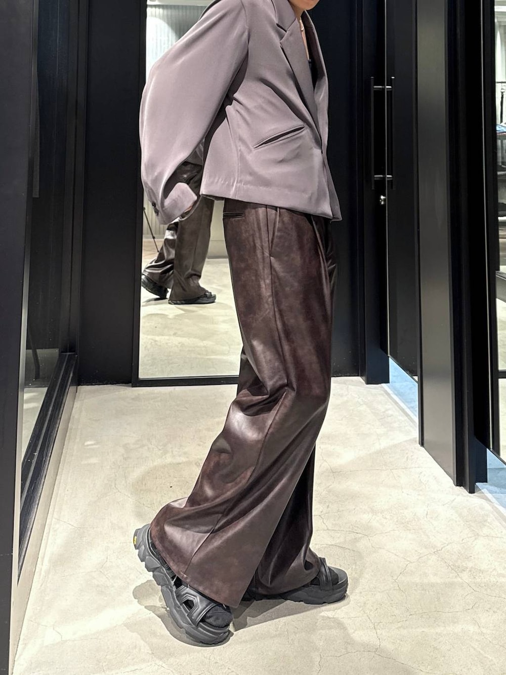 ブラック系のサンダル、ブラック系のタンクトップ、グレー系のテーラードジャケットを着用したメンズの夏コーディネートの3枚目の写真