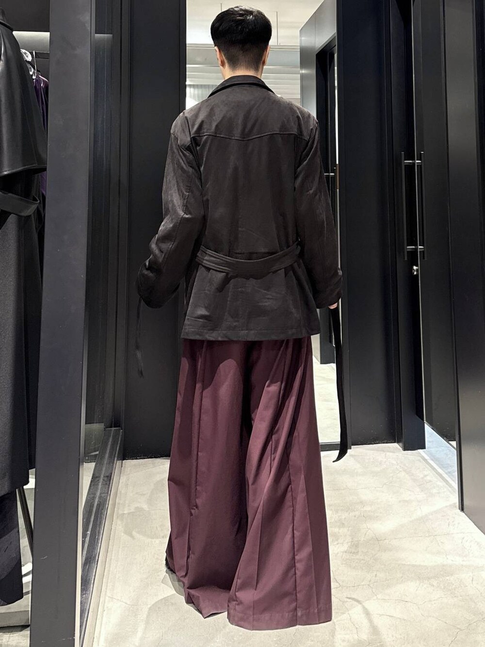 ブラック系のブーツ、レッド系のその他パンツ、ブラック系のミリタリージャケットを着用したメンズの秋コーディネートの3枚目の写真