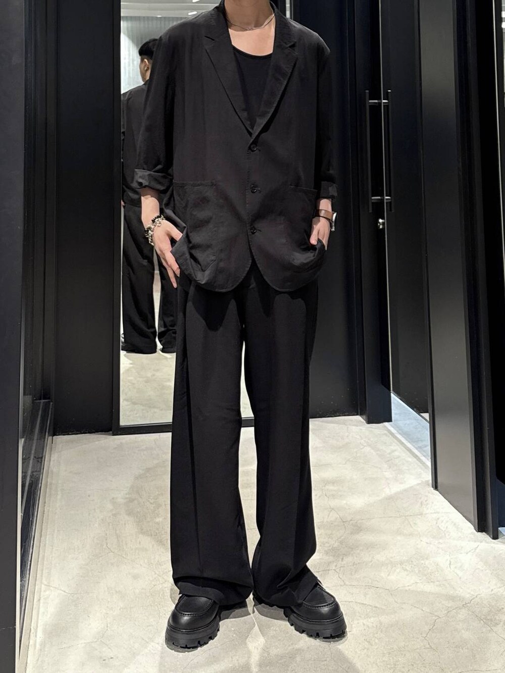 ブラック系のテーラードジャケット、ブラック系のドレスシューズ、ブラック系のスラックスを着用したメンズの秋コーディネートの4枚目の写真