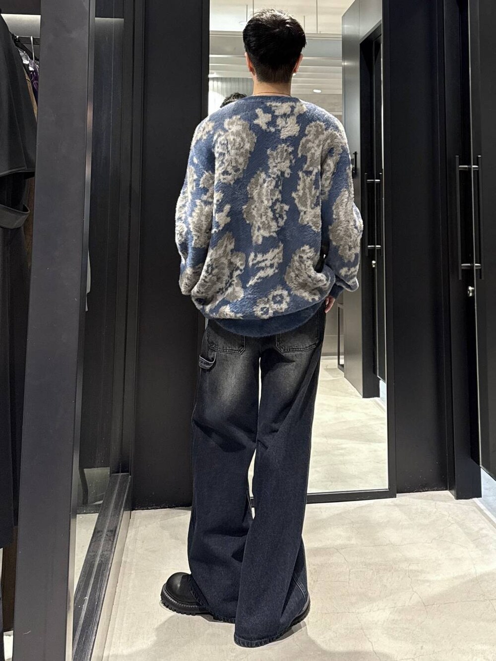 ブルー系のカーディガン/ボレロ、ブラック系のブーツ、ブルー系のデニムパンツを着用したメンズの秋コーディネートの3枚目の写真