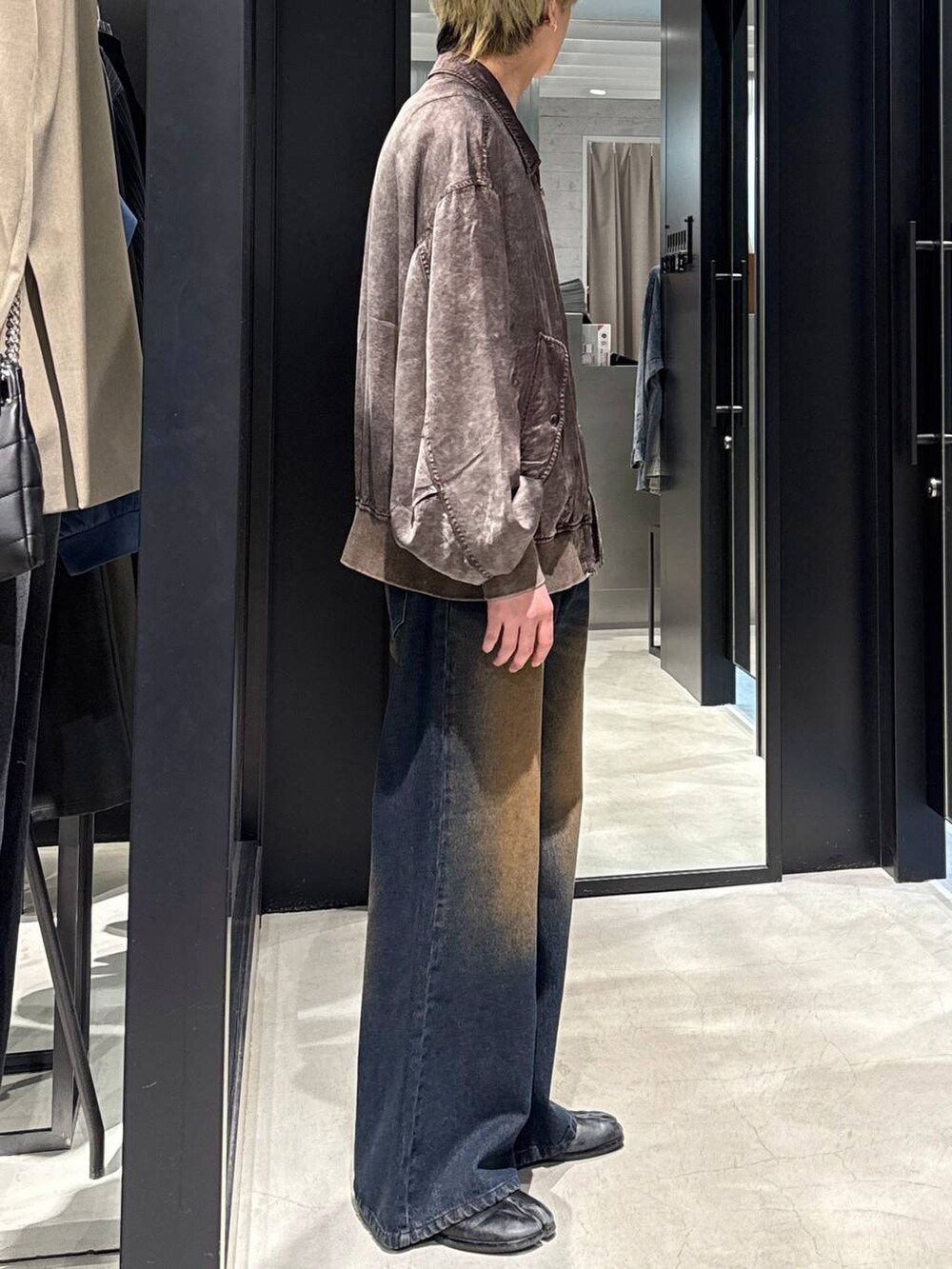 ブルー系のデニムパンツ、ブラック系のTシャツ/カットソー、ブラウン系のブルゾンを着用したメンズの冬コーディネートの2枚目の写真