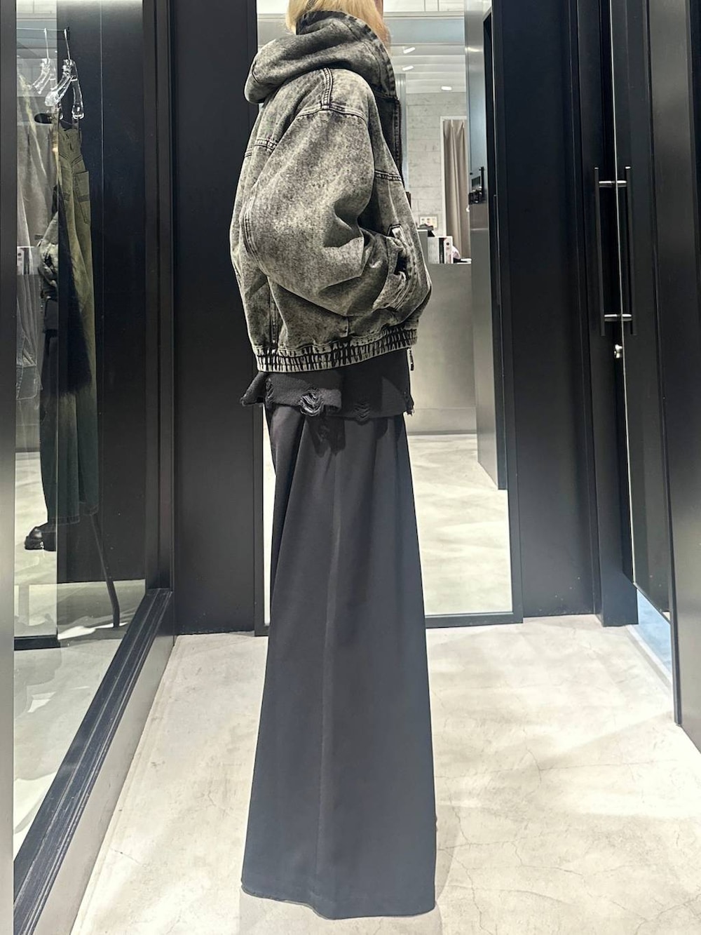 グリーン系のブルゾン、ブラック系のニット/セーター、ブラック系のスラックスを着用したメンズの秋コーディネートの2枚目の写真