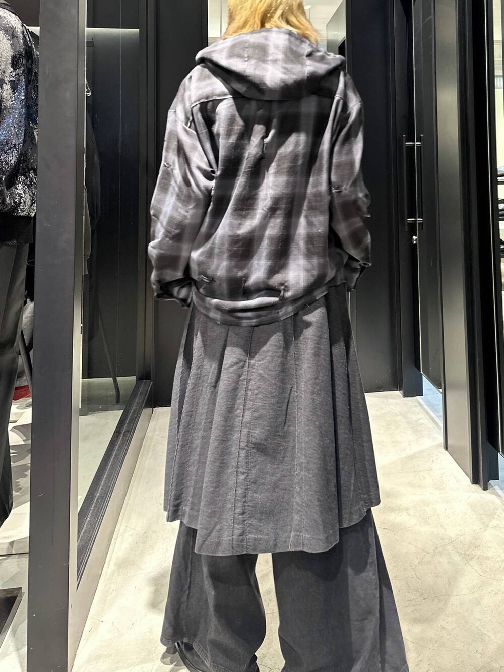 グレー系のスラックス、ブラック系のパーカー、ブラック系のキャップを着用したメンズの秋コーディネートの4枚目の写真