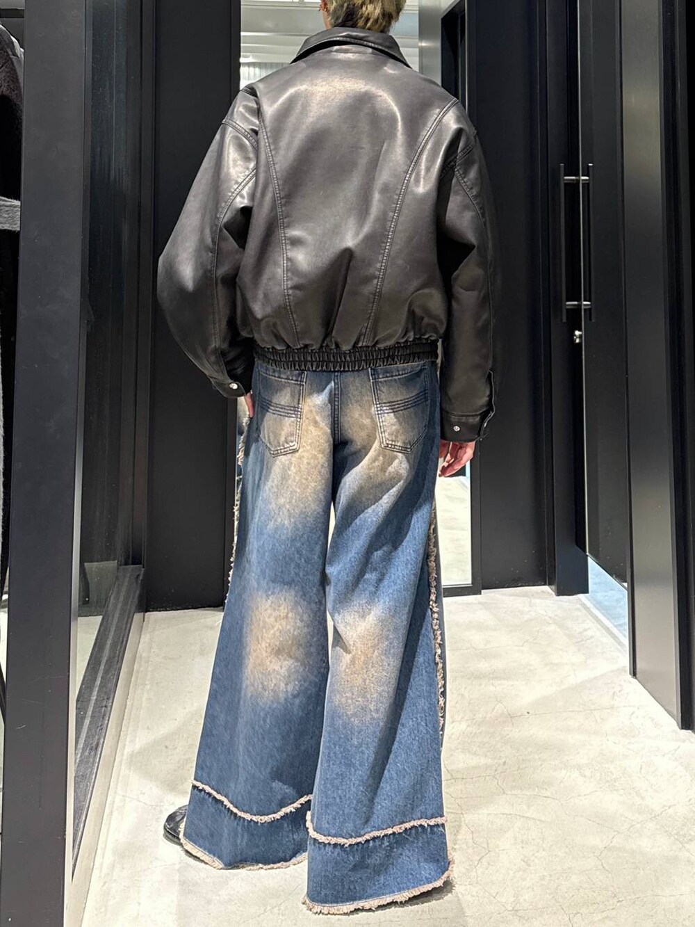 ブラック系のブルゾン、ブルー系のデニムパンツ、シルバー系のネックレスを着用したメンズの冬コーディネートの3枚目の写真