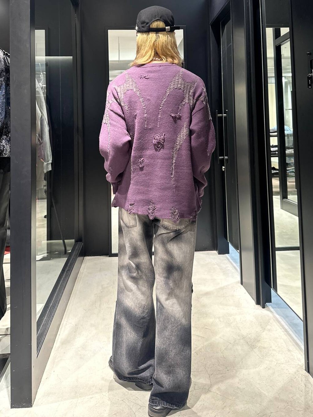 ブラック系のデニムパンツ、パープル系のニット/セーター、ブラック系のキャップを着用したメンズの秋コーディネートの4枚目の写真