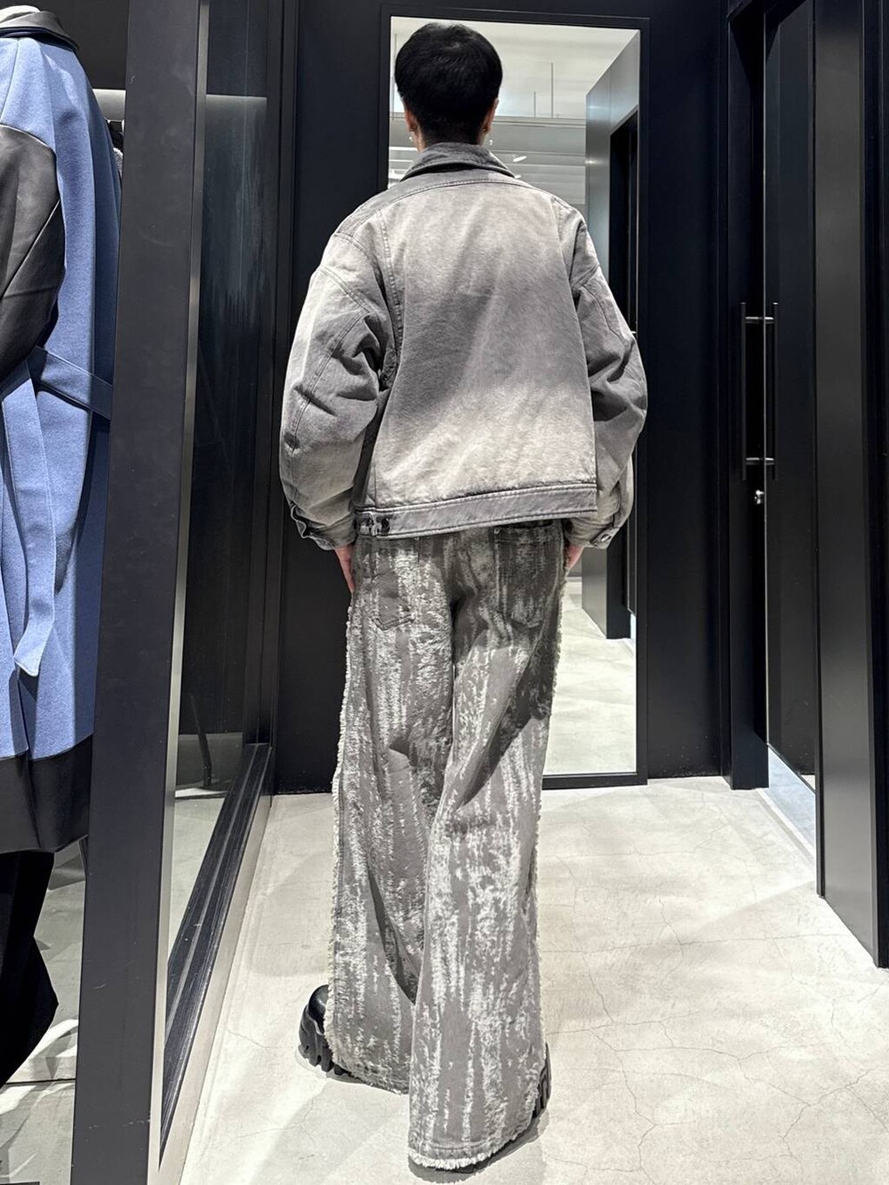 グレー系のブルゾン、ホワイト系のネックレスを着用したメンズの冬コーディネートの3枚目の写真