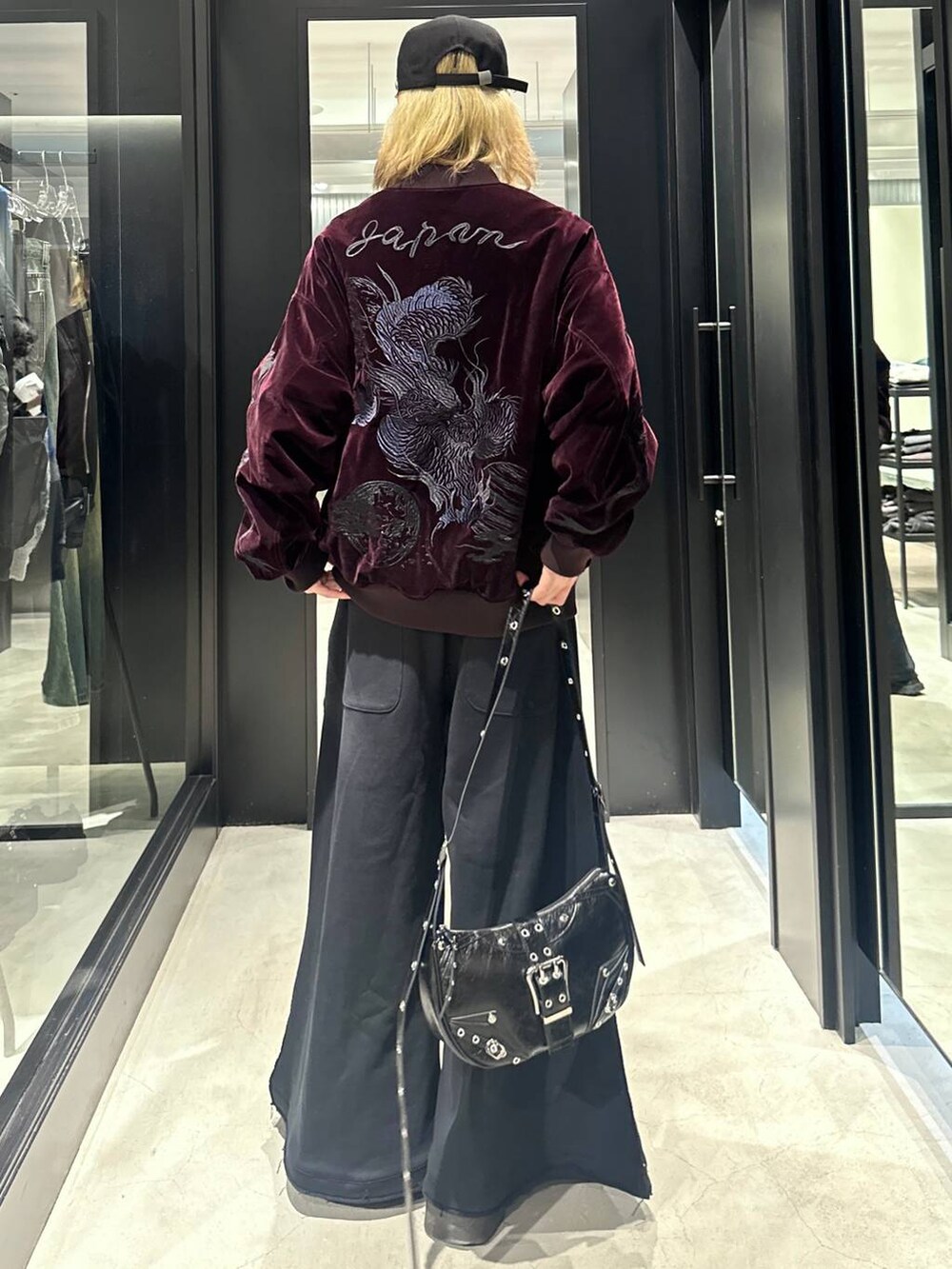ブラック系のスウェットパンツ、ブラック系のショルダーバッグ、レッド系のブルゾンを着用したメンズの秋コーディネートの3枚目の写真
