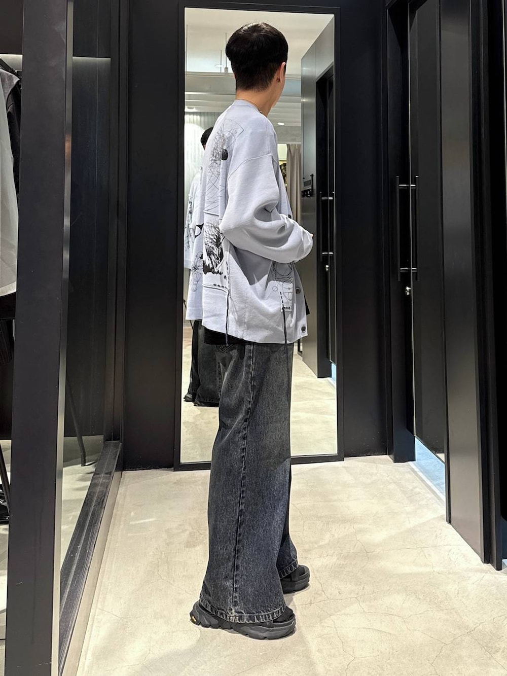 ブラック系のサンダル、ブルー系のデニムパンツ、ブラック系のTシャツ/カットソーを着用したメンズの夏コーディネートの2枚目の写真