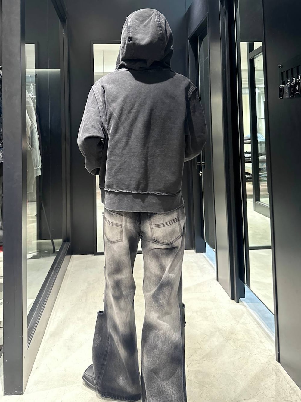 ブラック系のデニムパンツ、ブラック系のパーカー、ブラック系のキャップを着用したメンズの秋コーディネートの3枚目の写真