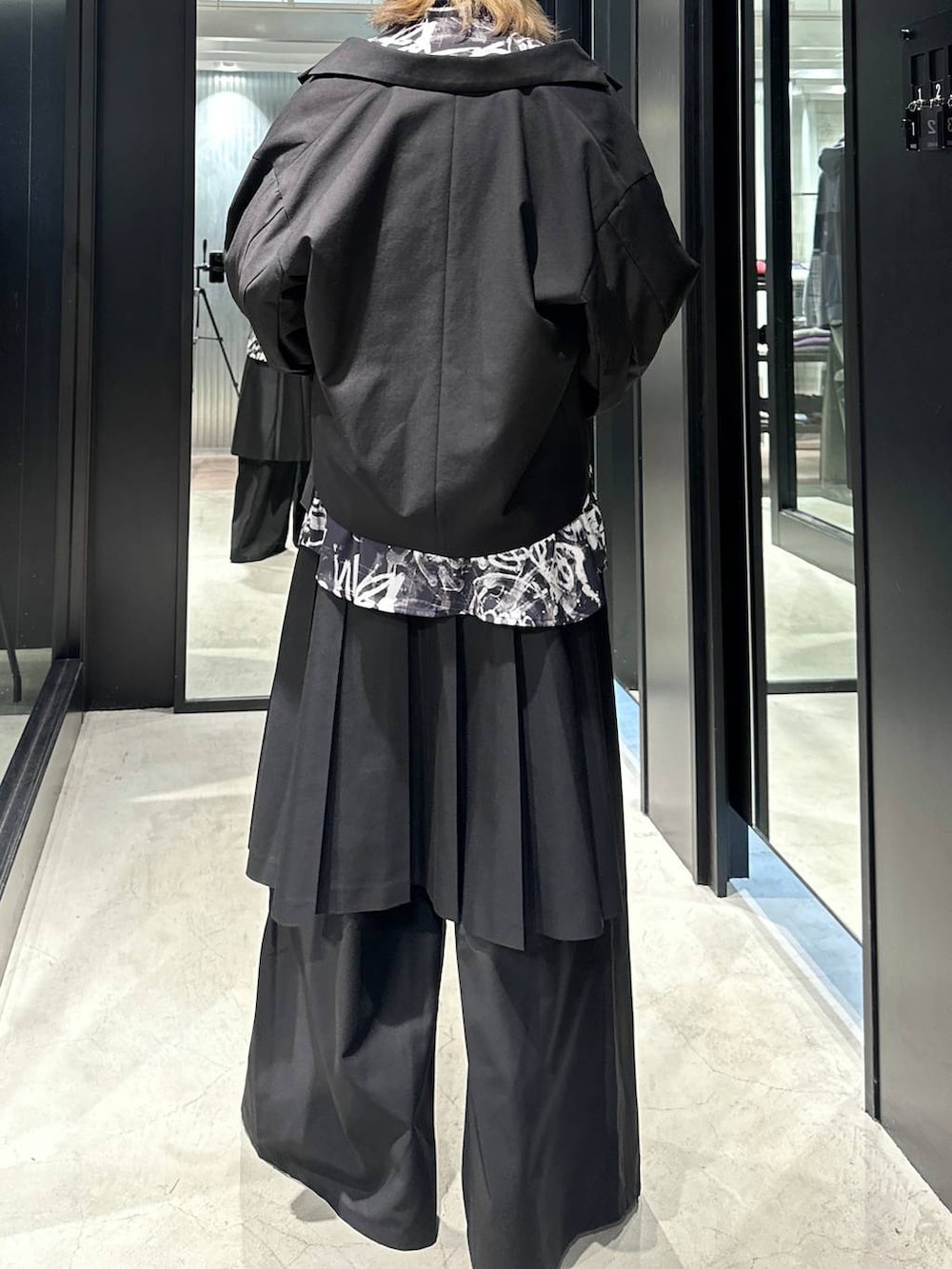 ブラック系のスラックス、ブラック系のブーツ、ブラック系のテーラードジャケットを着用したメンズの秋コーディネートの4枚目の写真