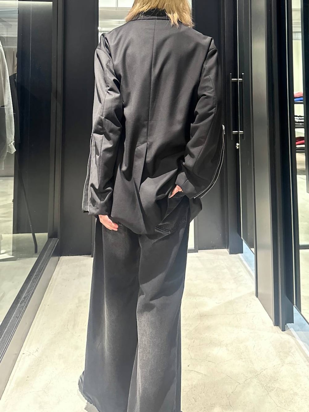 ブラック系のデニムパンツ、ブラック系のテーラードジャケット、ブラック系のドレスシューズを着用したメンズの秋コーディネートの4枚目の写真