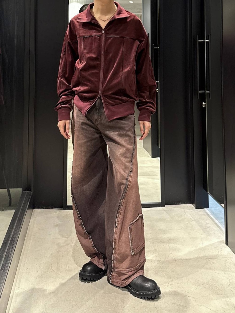 ホワイト系のTシャツ/カットソー、レッド系のデニムパンツ、ブラック系のブーツを着用したメンズの秋コーディネートの4枚目の写真