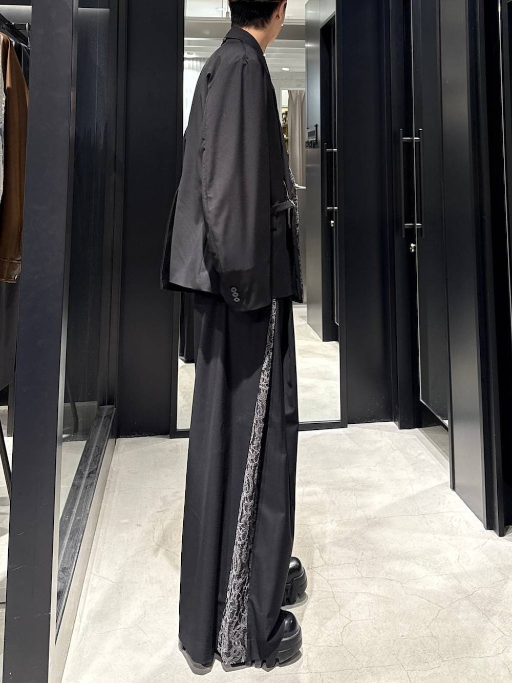 ブラック系のテーラードジャケット、ブラック系のその他パンツ、ホワイト系のネックレスを着用したメンズの冬コーディネートの2枚目の写真