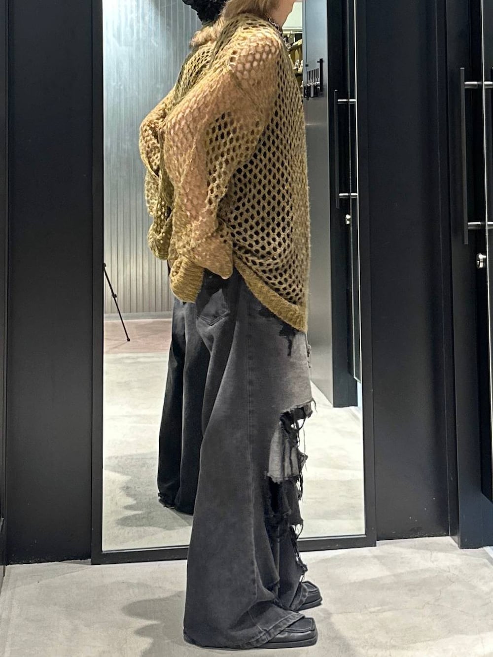 ブラック系のデニムパンツ、イエロー系のニット/セーター、シルバー系のネックレスを着用したメンズの秋コーディネートの3枚目の写真