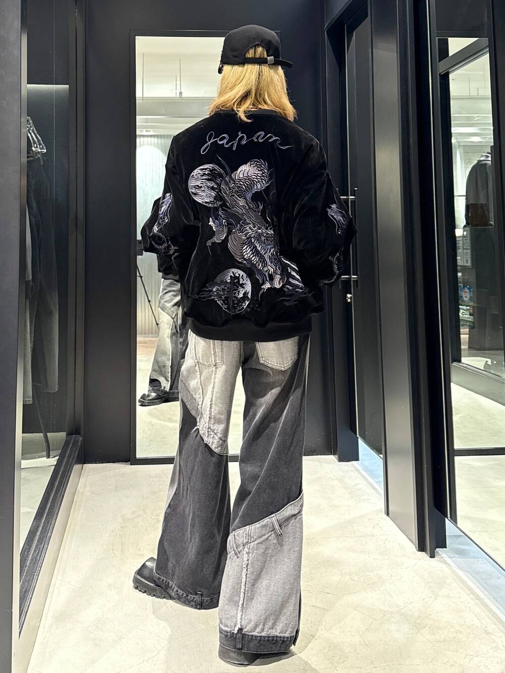 ブラック系のデニムパンツ、ブラック系のブルゾン、ブラック系のキャップを着用したメンズの秋コーディネートの3枚目の写真