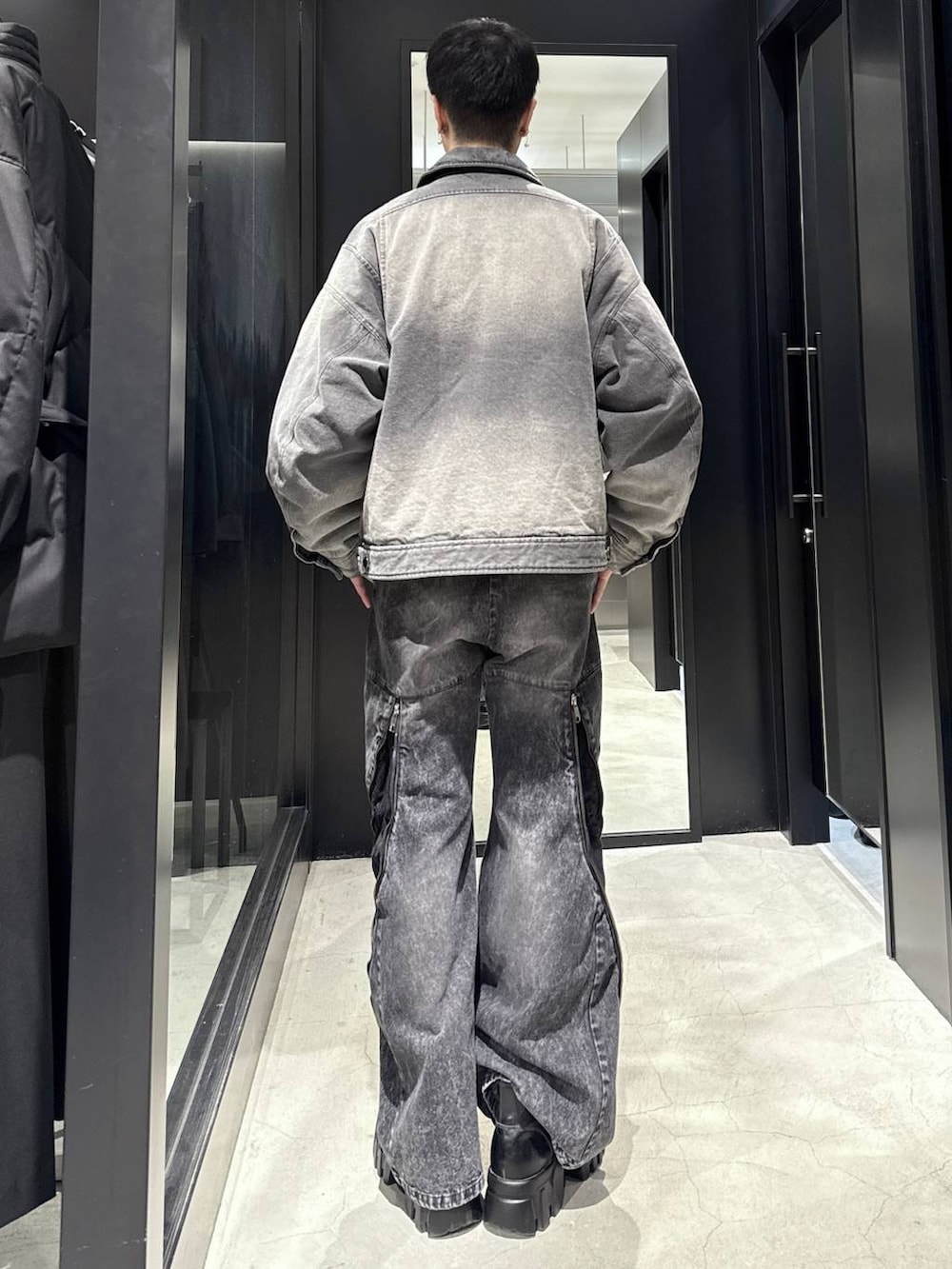 ブラック系のデニムパンツ、グレー系のブルゾン、シルバー系のネックレスを着用したメンズの冬コーディネートの3枚目の写真