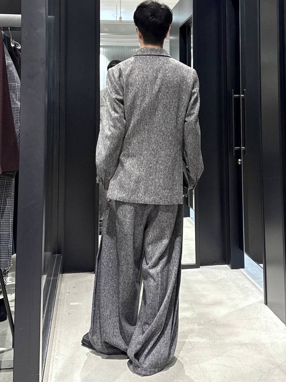 ブラック系のスラックス、ブラック系のテーラードジャケットを着用したメンズの秋コーディネートの4枚目の写真