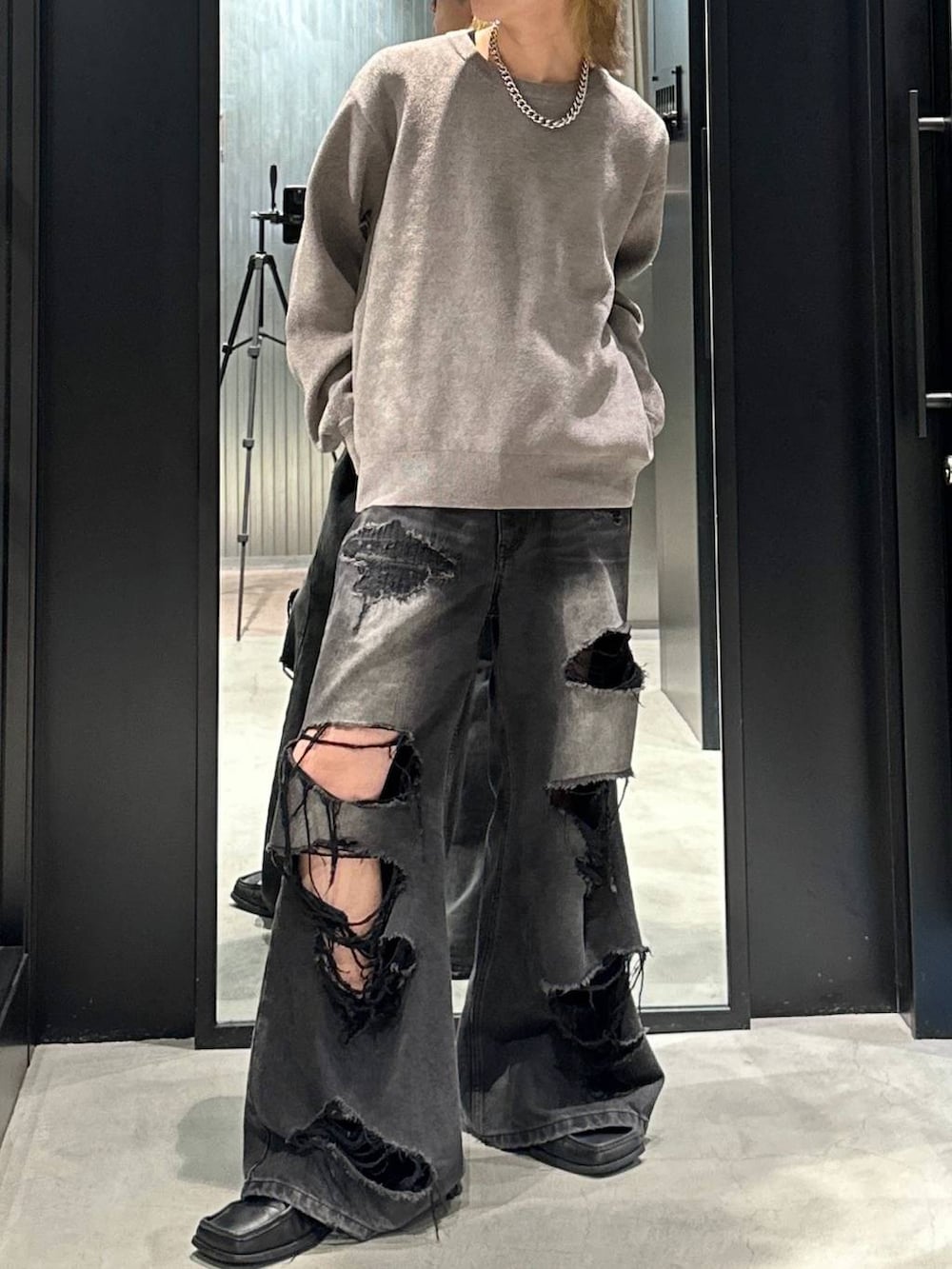 ブラック系のデニムパンツ、グレー系のニット/セーター、ブラック系のキャップを着用したメンズの秋コーディネートの2枚目の写真