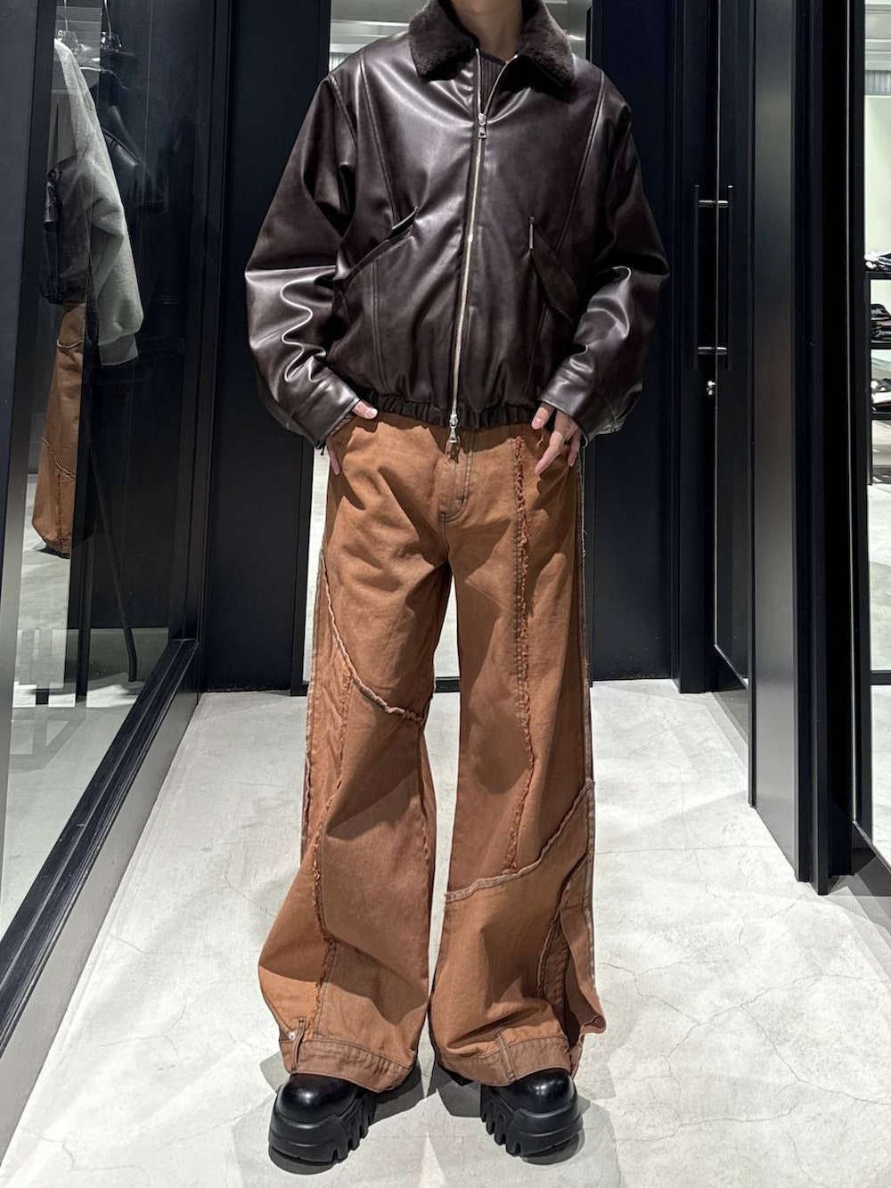 ブラウン系のブルゾン、オレンジ系のデニムパンツ、シルバー系のネックレスを着用したメンズの冬コーディネートの4枚目の写真