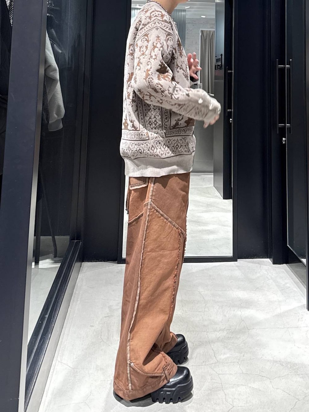 ブラック系のカーディガン/ボレロ、オレンジ系のデニムパンツ、シルバー系のネックレスを着用したメンズの冬コーディネートの2枚目の写真