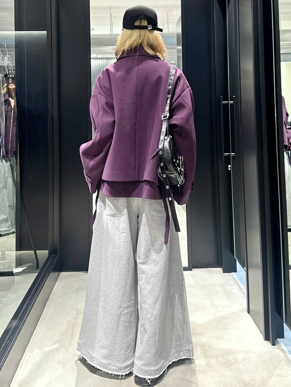 グレー系のスウェットパンツ、ブラック系のショルダーバッグ、パープル系のブルゾンを着用したメンズの秋コーディネートの4枚目の写真
