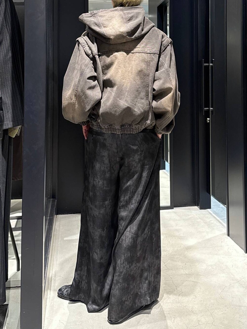 ブラック系のTシャツ/カットソー、グレー系のスラックス、ブラウン系のブルゾンを着用したメンズの冬コーディネートの3枚目の写真