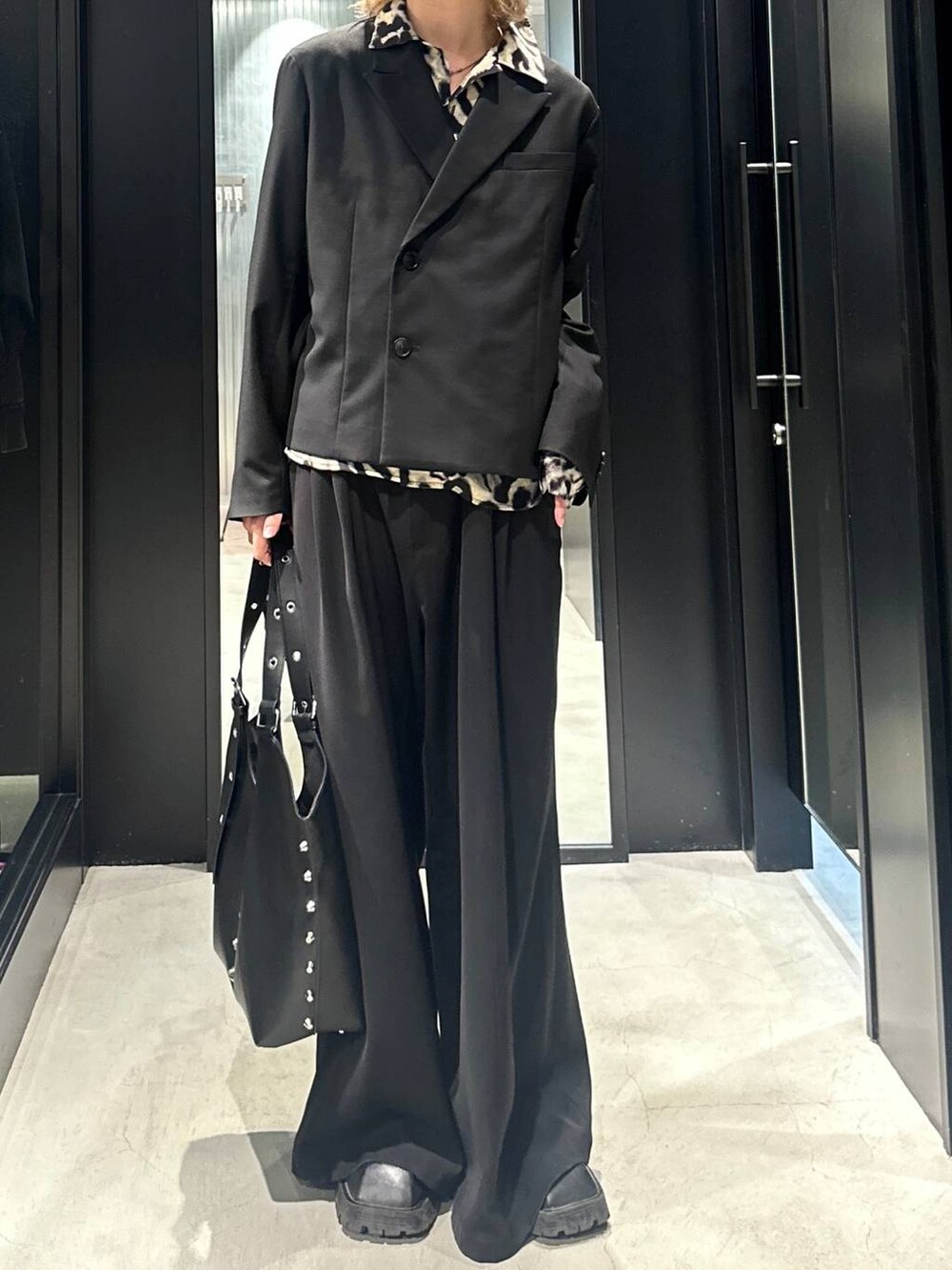 ブラック系のスラックス、ブラック系のテーラードジャケット、ブラック系のトートバッグを着用したメンズの秋コーディネートの3枚目の写真