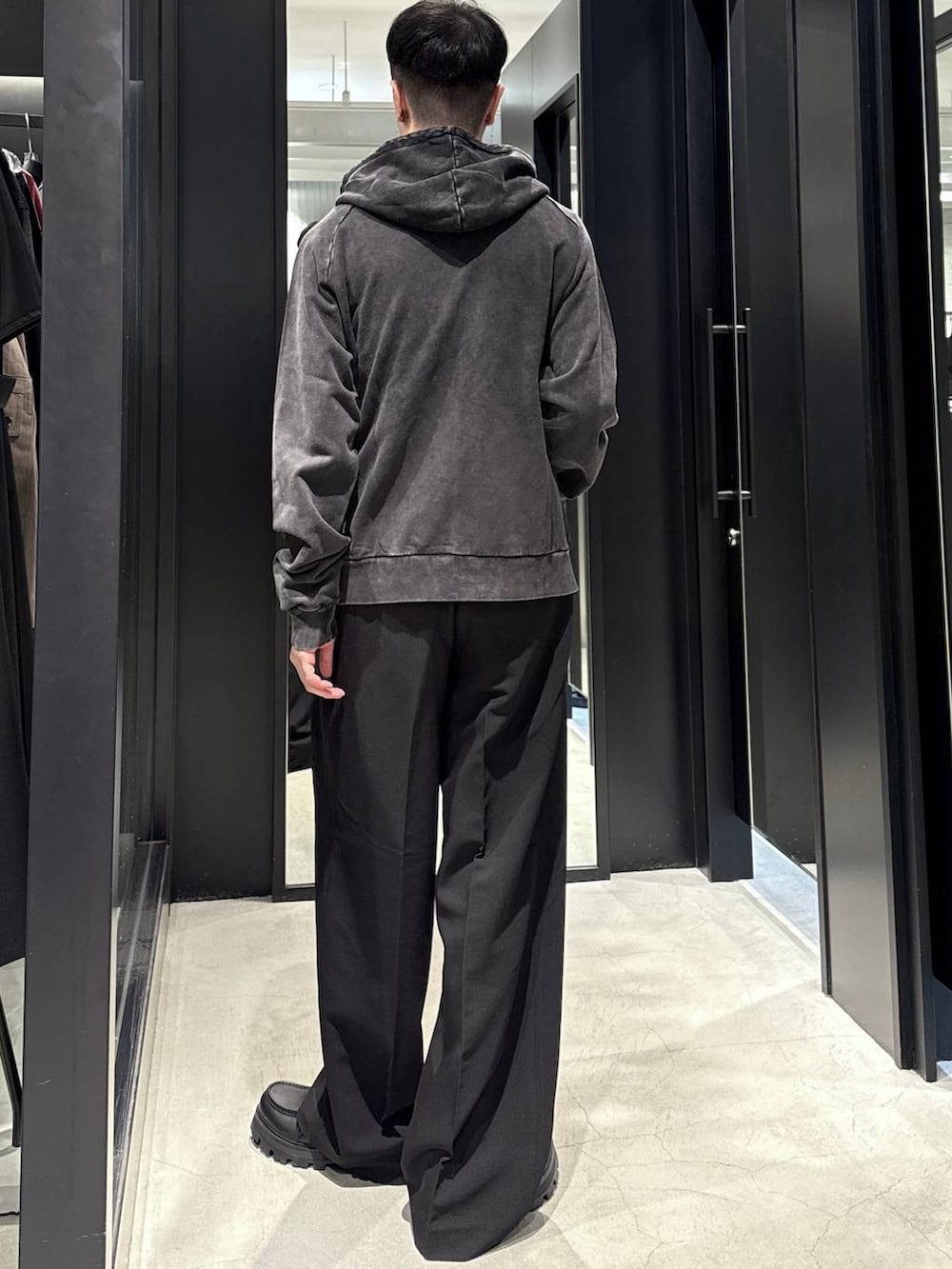 ブラック系のパーカー、ブラック系のTシャツ/カットソー、ブラック系のドレスシューズを着用したメンズの秋コーディネートの3枚目の写真