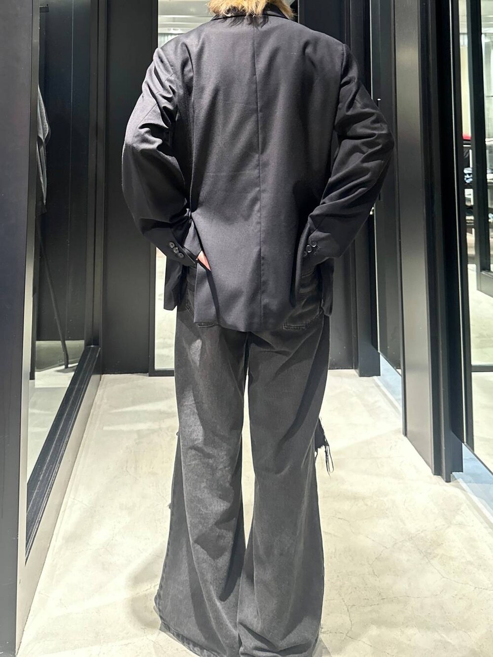 ブラック系のデニムパンツ、ブラック系のテーラードジャケット、シルバー系のネックレスを着用したメンズの秋コーディネートの4枚目の写真