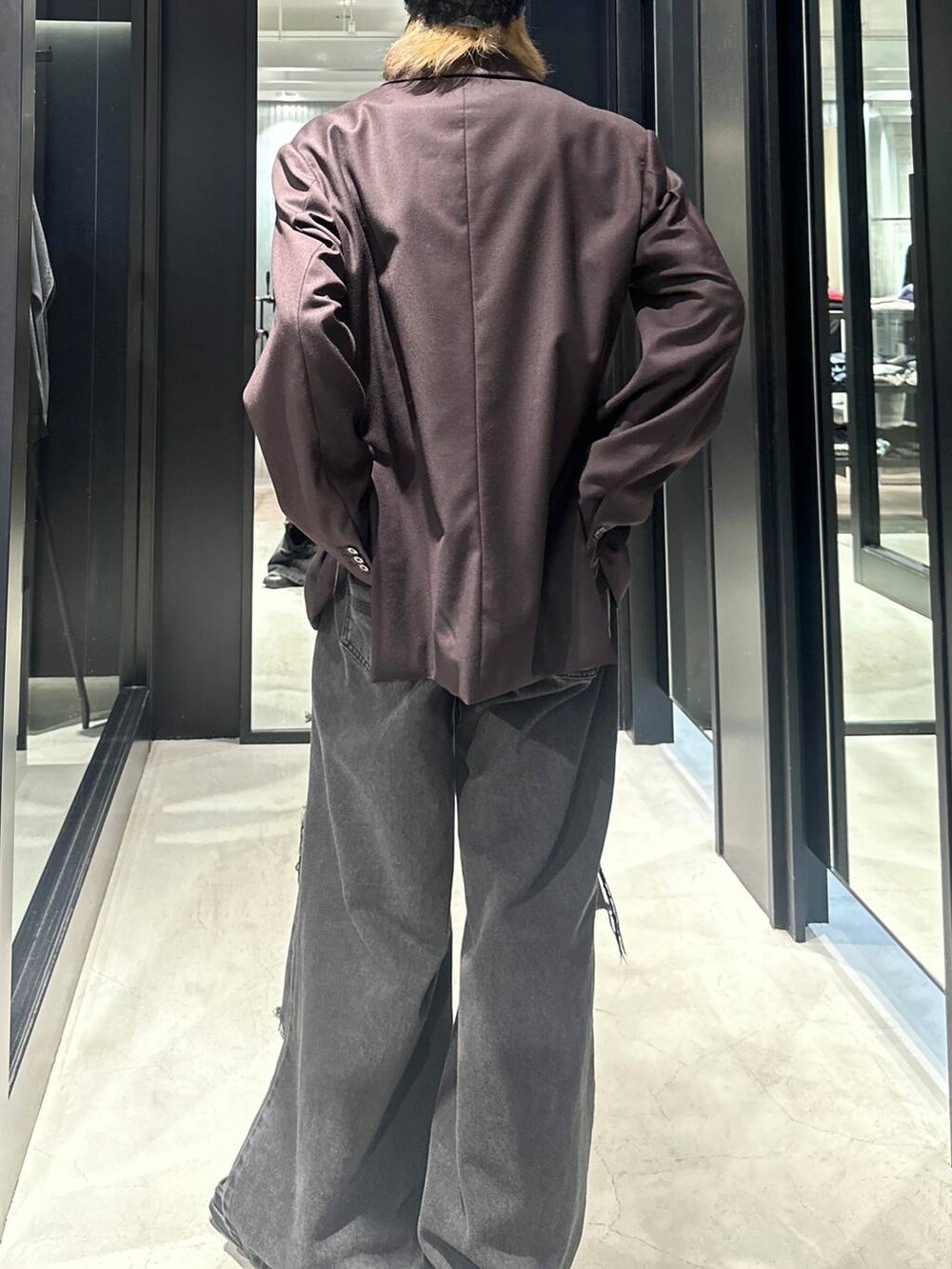 ブラック系のデニムパンツ、ブラウン系のテーラードジャケット、シルバー系のネックレスを着用したメンズの秋コーディネートの4枚目の写真