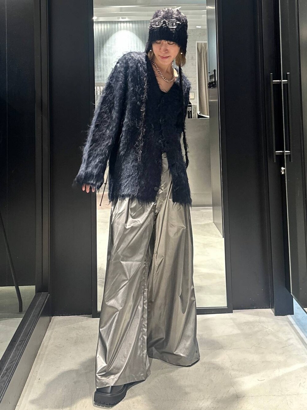 シルバー系のスラックス、ブルー系のカーディガン/ボレロ、ブラック系のドレスシューズを着用したメンズの秋コーディネートの5枚目の写真