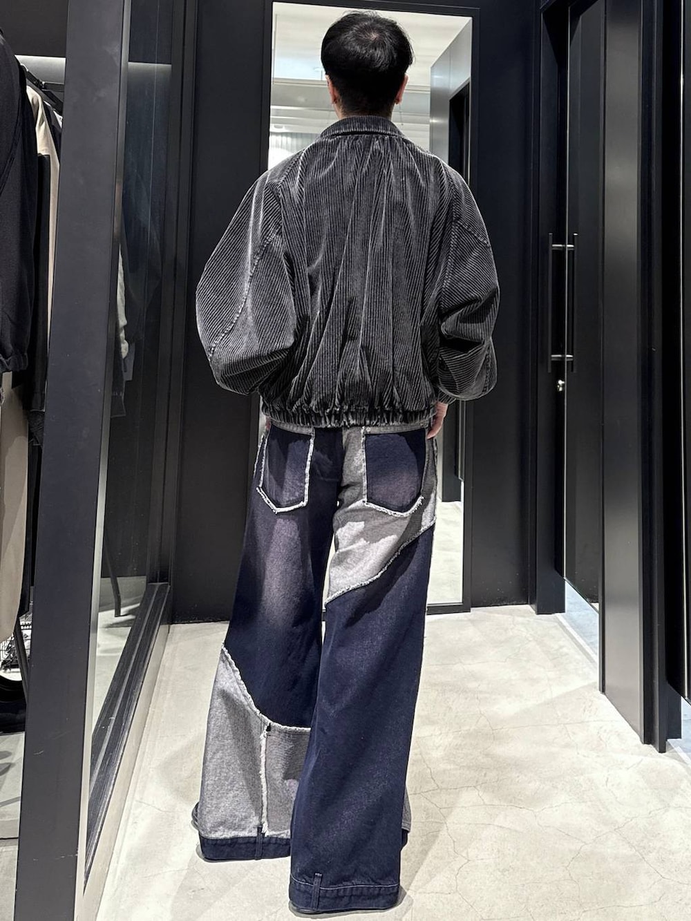 ブラック系のブルゾン、ブルー系のデニムパンツ、ブラック系のスウェットを着用したメンズの秋コーディネートの3枚目の写真