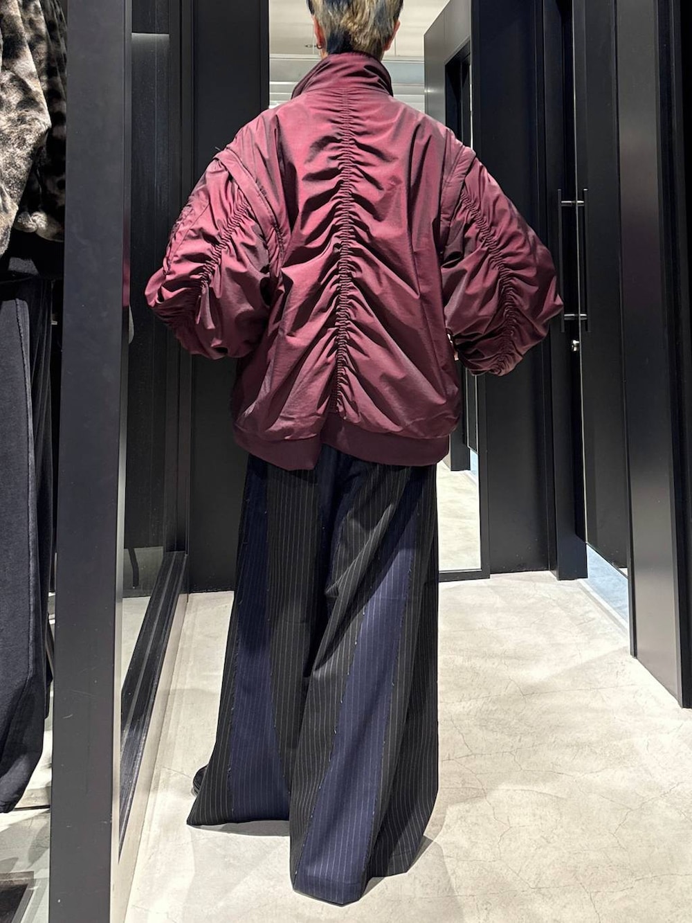 レッド系のブルゾン、ブラック系のその他パンツ、シルバー系のネックレスを着用したメンズの冬コーディネートの3枚目の写真