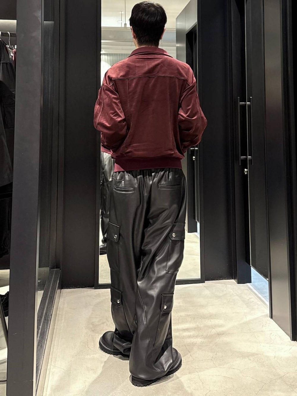 ブラック系のタンクトップ、ブラック系のカーゴパンツ、ブラック系のブーツを着用したメンズの秋コーディネートの3枚目の写真