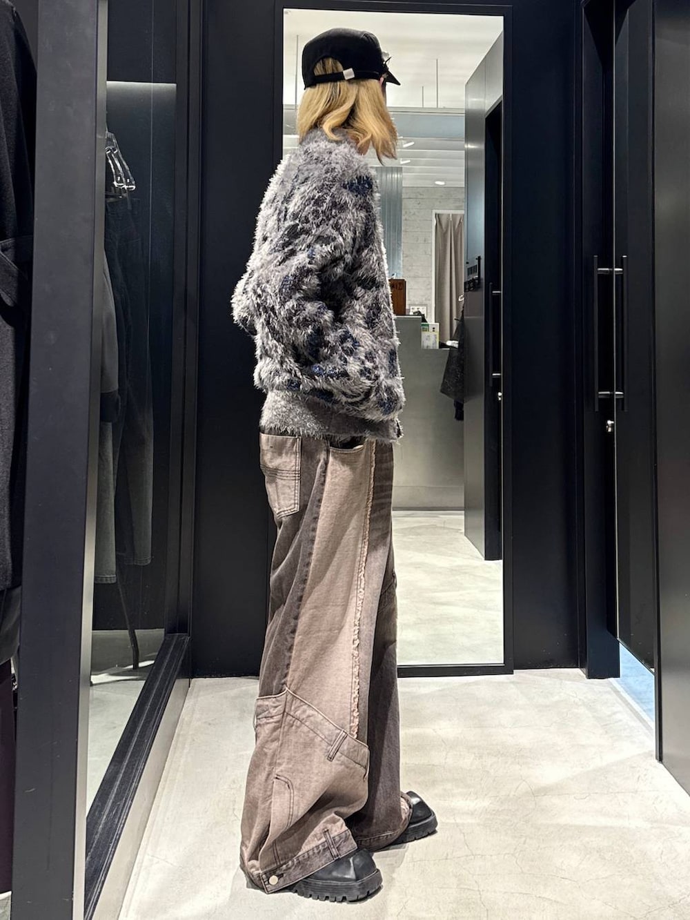 ブラウン系のデニムパンツ、グレー系のニット/セーター、ブラック系のキャップを着用したメンズの秋コーディネートの2枚目の写真