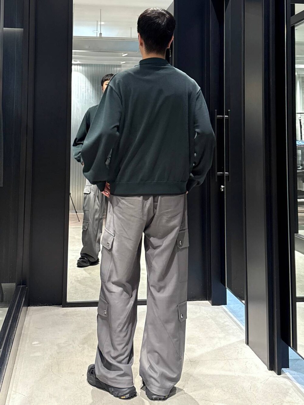 ブラック系のサンダル、ブラック系のタンクトップ、グレー系のカーゴパンツを着用したメンズの夏コーディネートの3枚目の写真