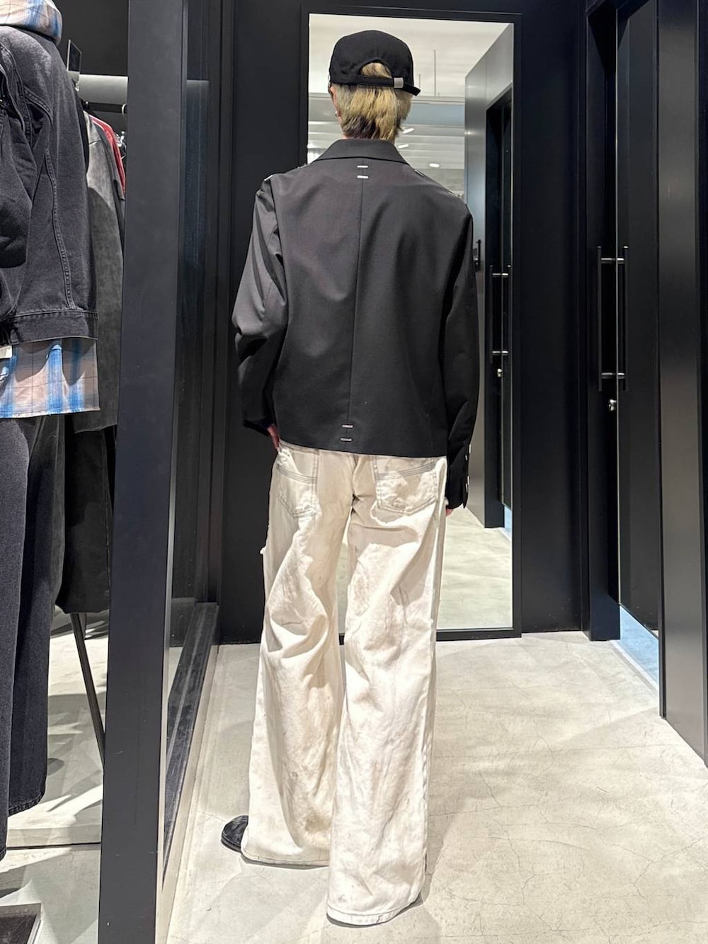 ブラック系のテーラードジャケット、ホワイト系のデニムパンツ、ブラック系のキャップを着用したメンズの冬コーディネートの3枚目の写真