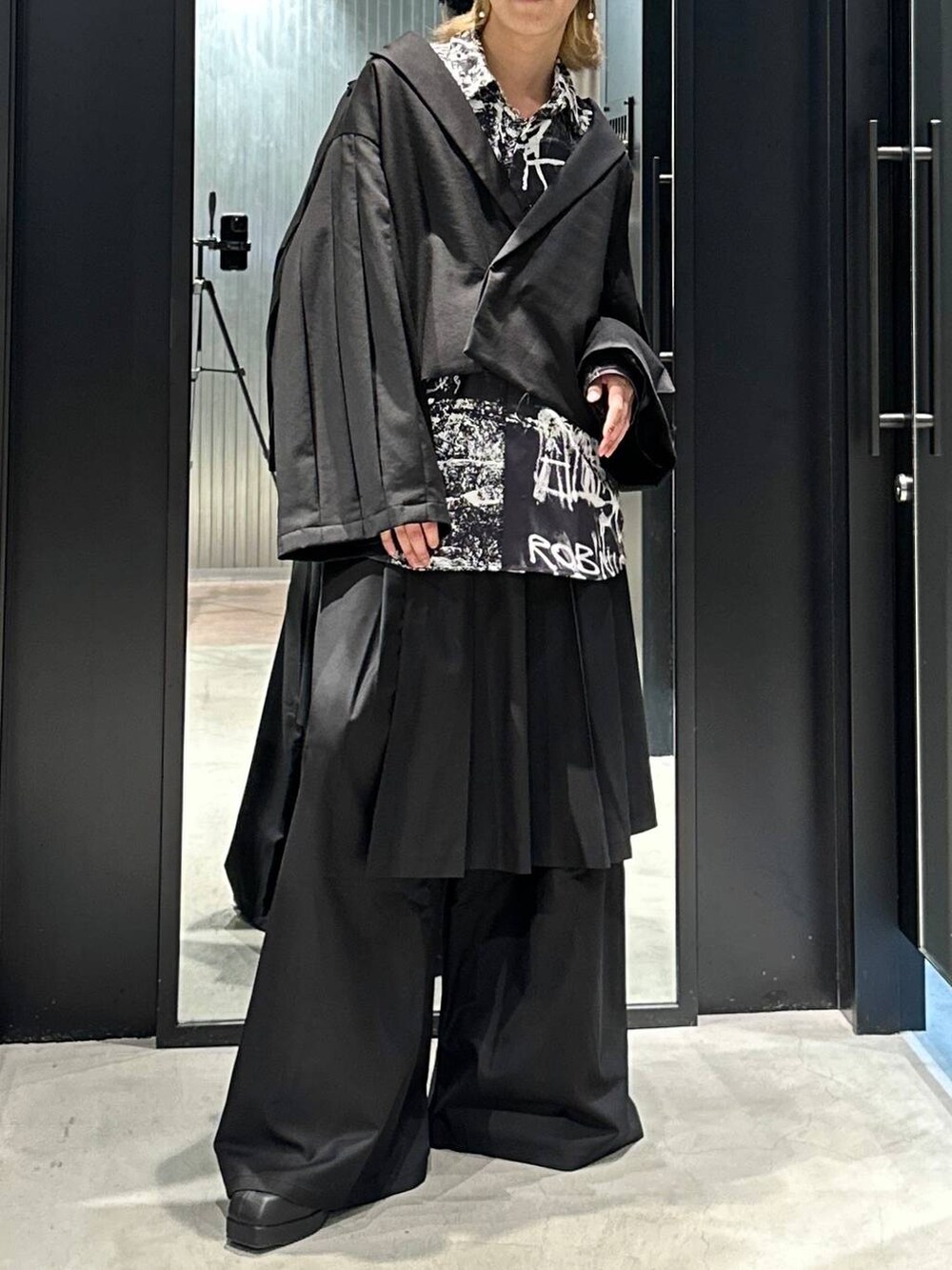 ブラック系のスラックス、ブラック系のブーツ、ブラック系のテーラードジャケットを着用したメンズの秋コーディネートの2枚目の写真