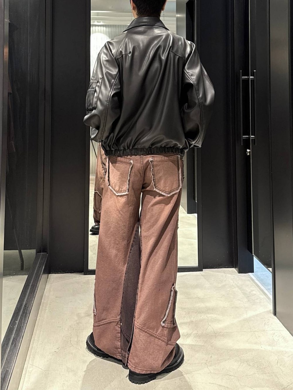 ホワイト系のTシャツ/カットソー、ブラック系のブルゾン、レッド系のデニムパンツを着用したメンズの秋コーディネートの3枚目の写真