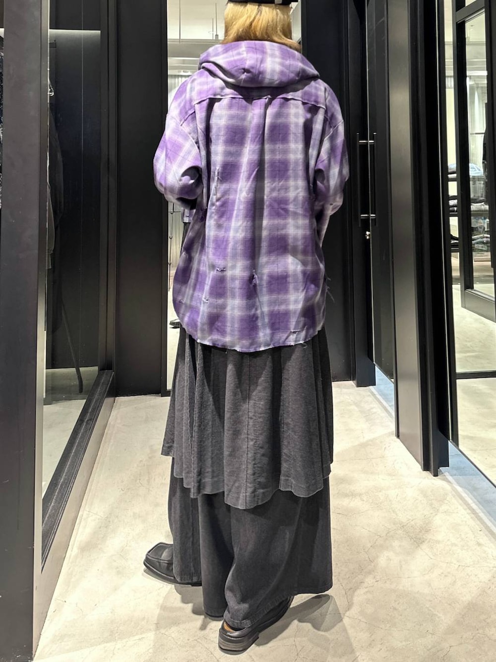 グレー系のスラックス、パープル系のパーカー、ブラック系のキャップを着用したメンズの秋コーディネートの4枚目の写真