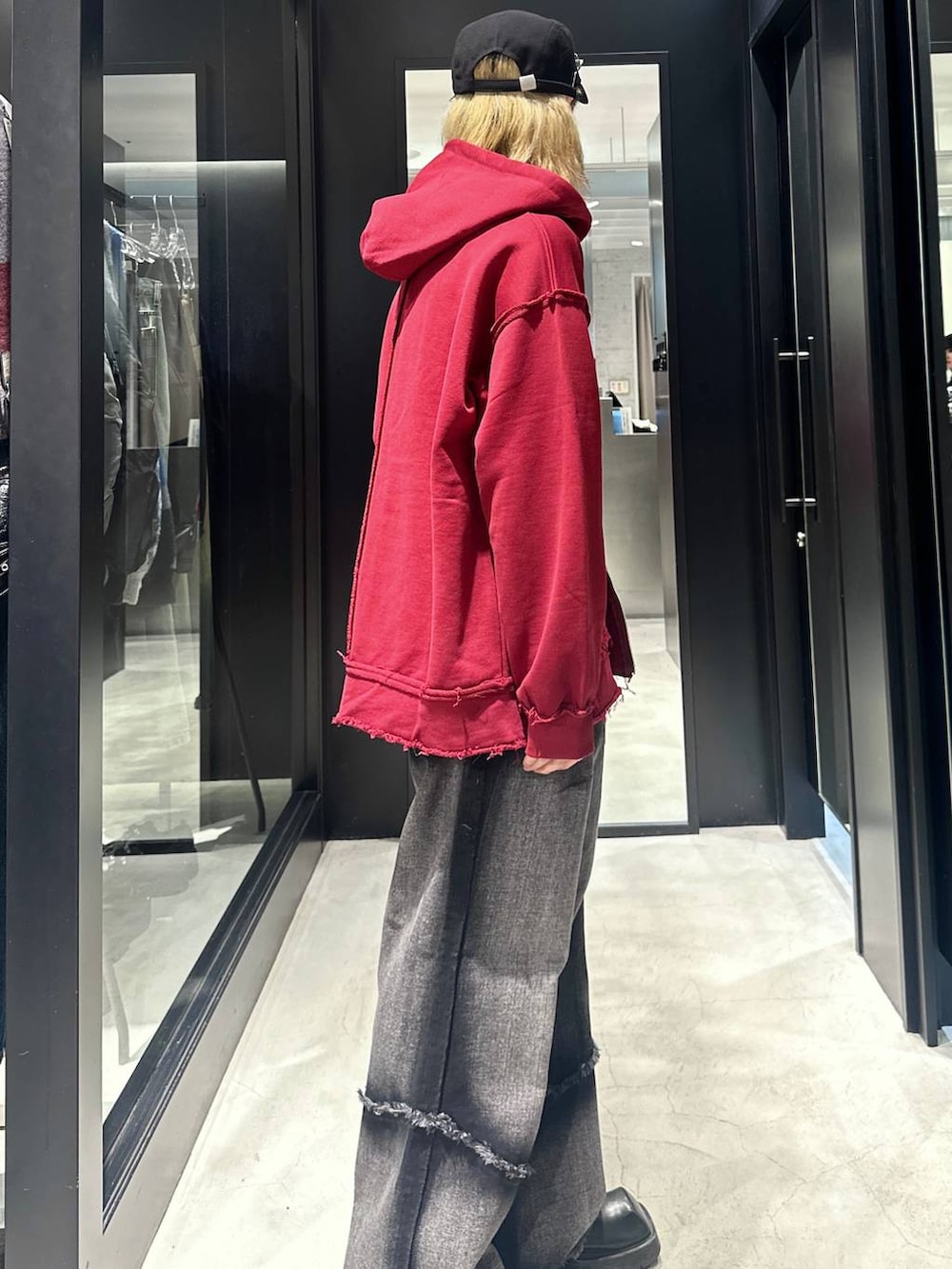 ブラック系のデニムパンツ、グレー系のパーカー、ブラック系のキャップを着用したメンズの秋コーディネートの2枚目の写真