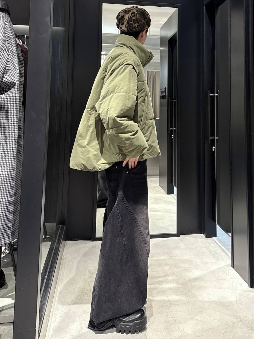 ブラック系のデニムパンツ、グリーン系のダウンジャケット/コート、ブラック系のカーディガン/ボレロを着用したメンズの秋コーディネートの2枚目の写真